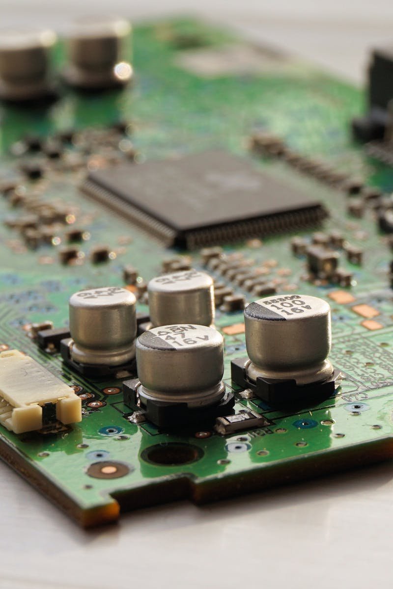 Detailed view of a green circuit board featuring capacitors and microchips.